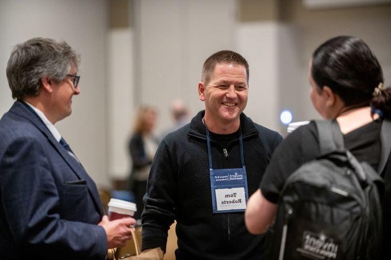 Three attendees network at the conference