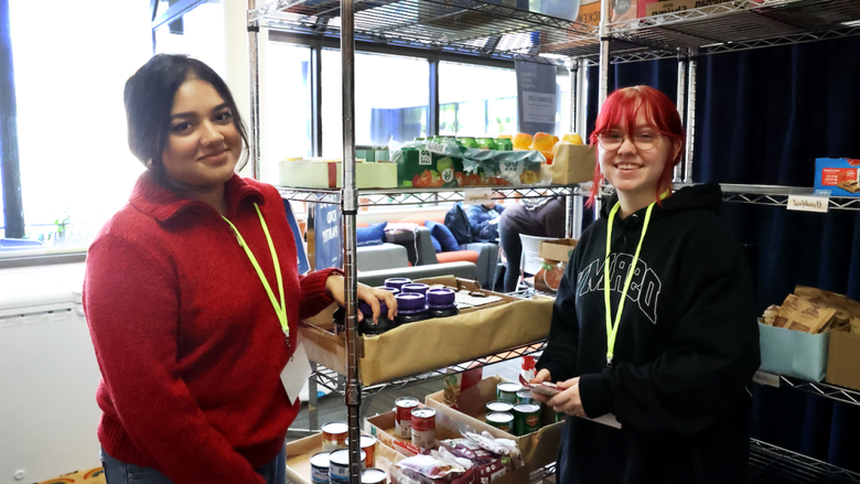 Students standing in front of the 社会影响中心's food pantry