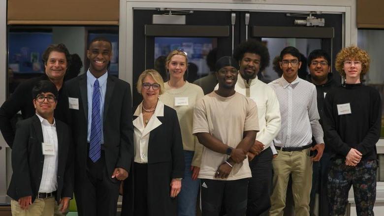 students posing for photo with administrators and coaches