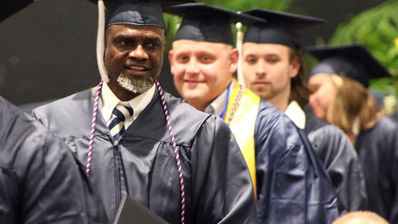 Graduates wearing caps and gowns smiling