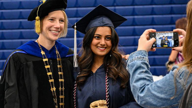 graduate and chancellor smiling for a photo