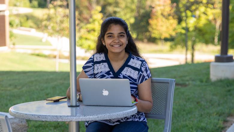 Renusree B和aru studying outdoors at the 宾州州立大学白兰地酒 campus. 