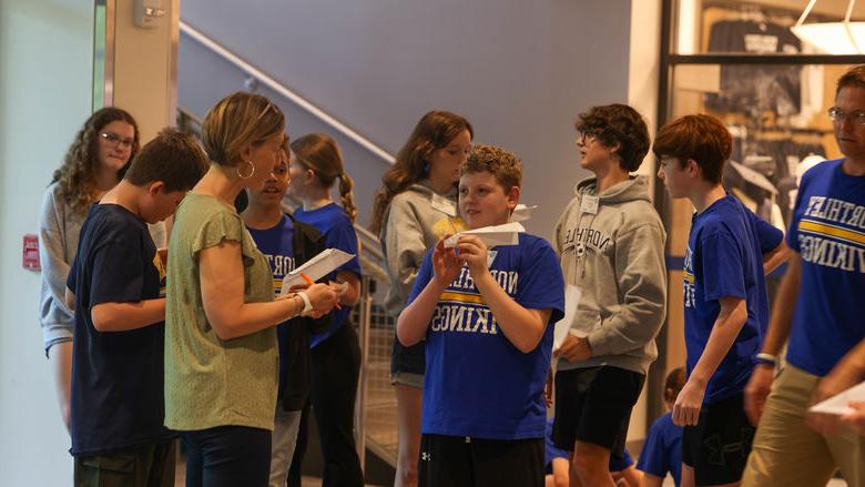 students flying paper airplanes