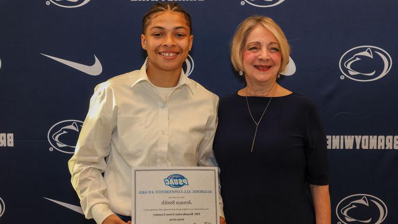 student holding award with Chancellor Wells